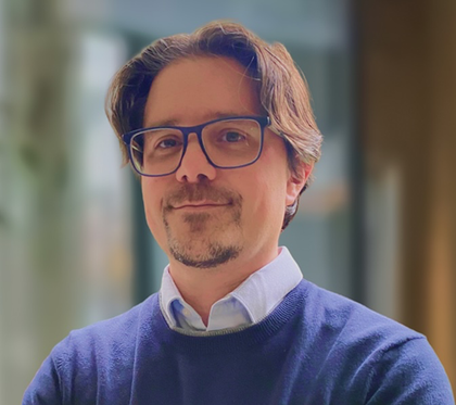 Scott Anderson in glasses and a navy jumper, smiling at the camera